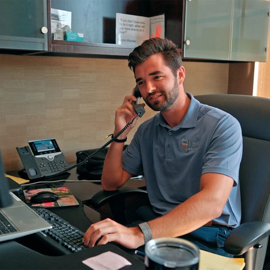 Loft Advisors employee talks on phone at desk